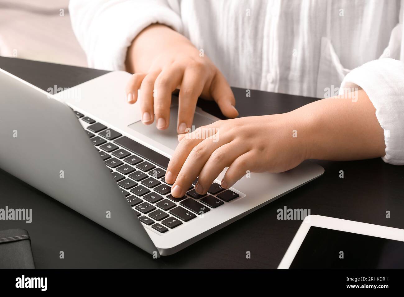 Female programmer typing on laptop keyboard at her workplace in office ...