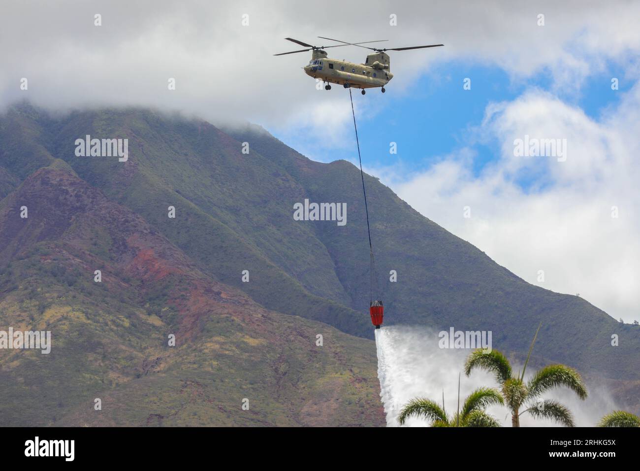 Lahaina, United States. 16 August, 2023. A U.S. Army CH-47 Chinook helicopter drops seawater around the perimeter of the area where wildfires swept across Western Maui, August 16, 2023 in Lahaina, Maui, Hawaii. Wildfires fanned by high winds killed at least 100 people and destroyed thousands of homes on the island.  Credit: Spc. Tonia Ciancanelli/U.S. National Guard/Alamy Live News Stock Photo