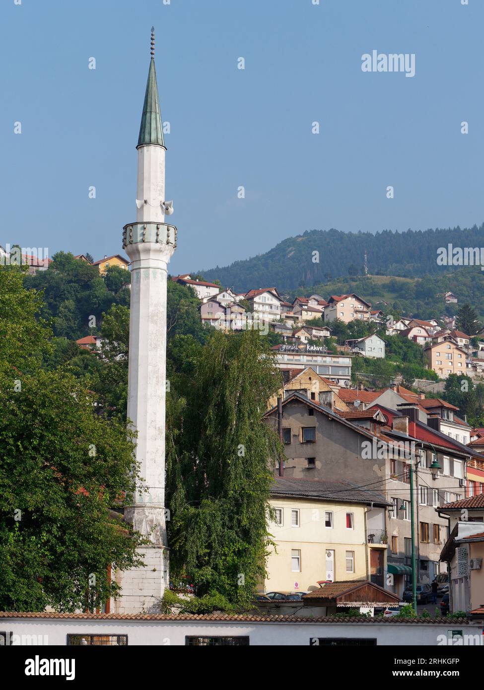 iMinaret with houses and a hill behind n the city Sarajevo, Bosnia and Herzegovina, August 17,2023. Stock Photo