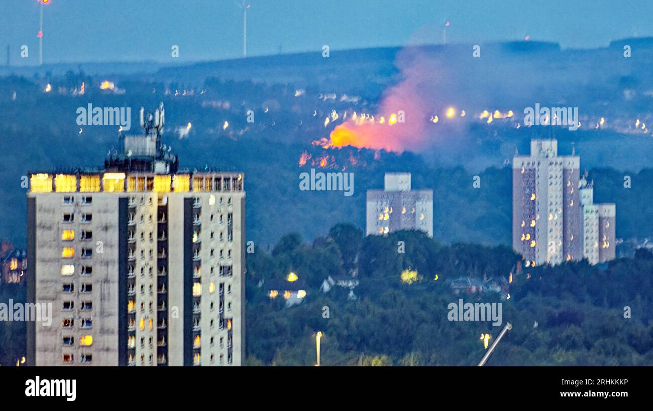 Glasgow, Scotland, UK. 17th  August, 2023.   Huge fire south of the city as Eight fire engines attend blaze at former hotel in Carmunnock derelict Carnbooth House Hôtel pictured from ten miles away beyond the towers of pollokshields un the city.  Credit Gerard Ferry/Alamy Live News Stock Photo