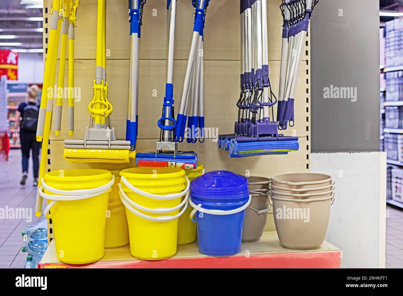 yellow and blue mops for mopping floors with buckets on the shop