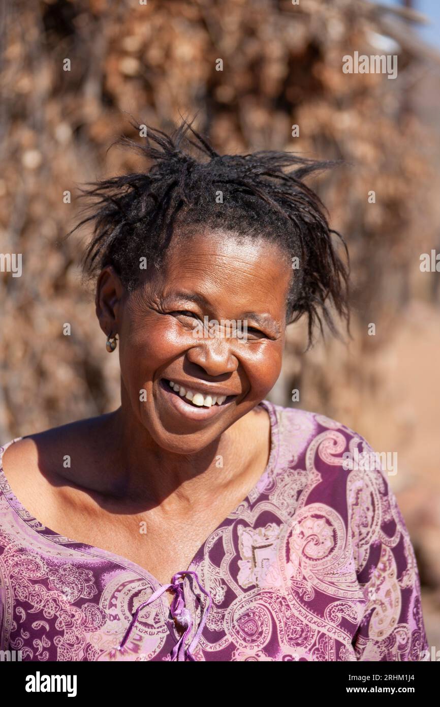 african woman in the village standing in the backyard with a smiling face in the bright sun Stock Photo