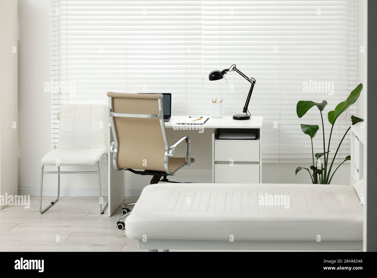 Modern medical office with doctor's workplace and examination table in ...