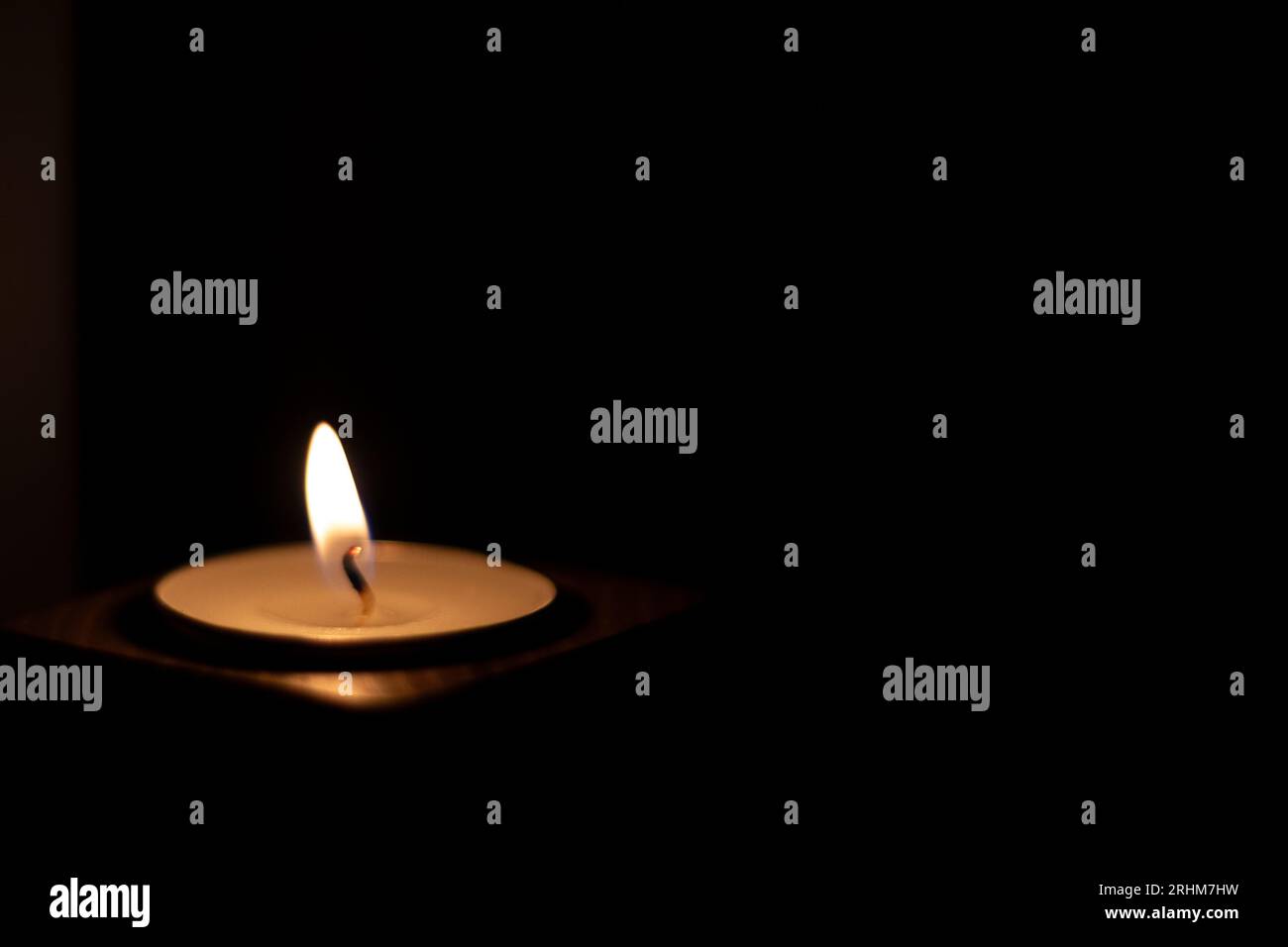 Close-up of flame burning on candle isolated on a black background. Center Stock Photo