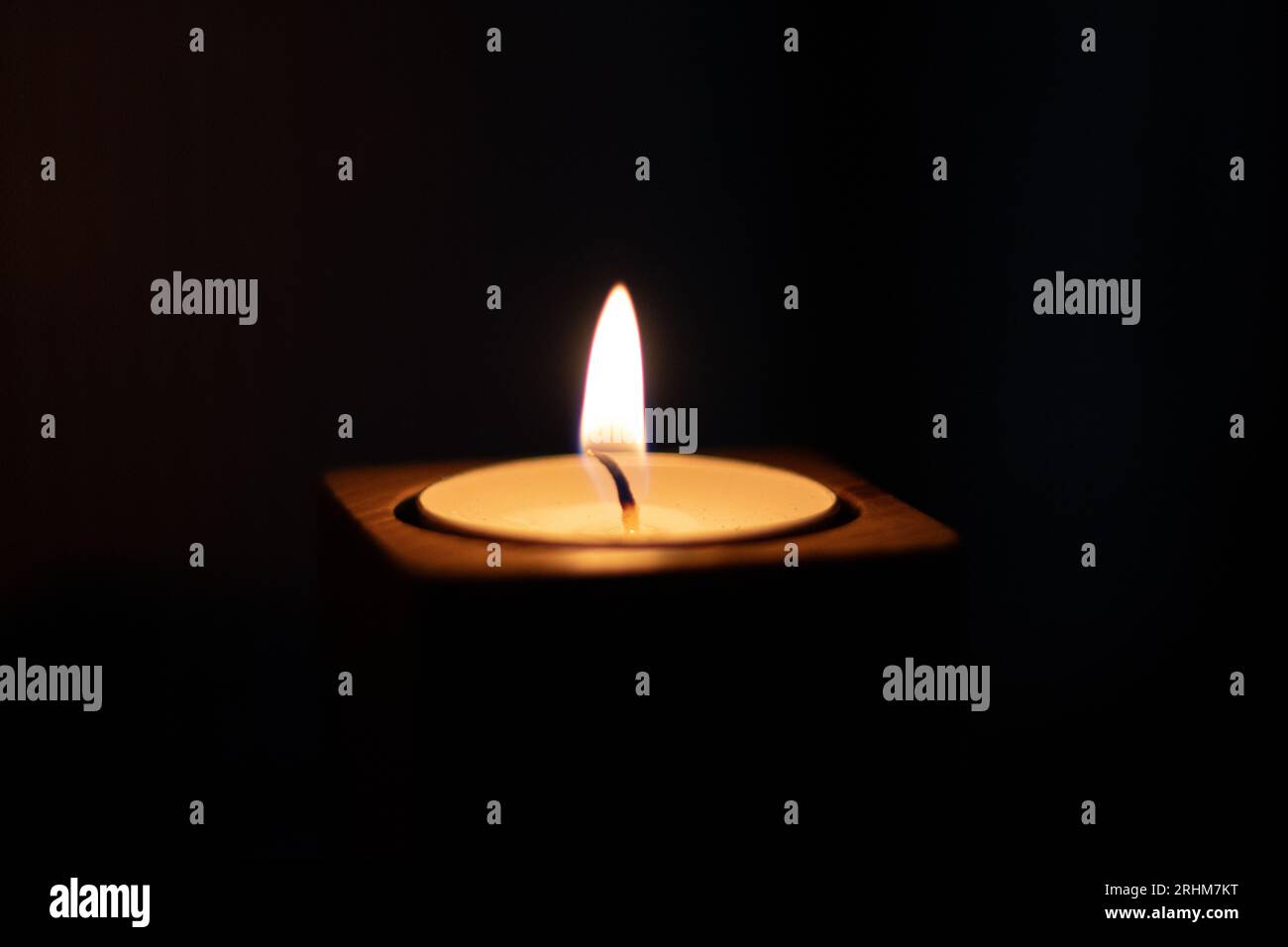 Close-up of flame burning on candle isolated on a black background. Center Stock Photo
