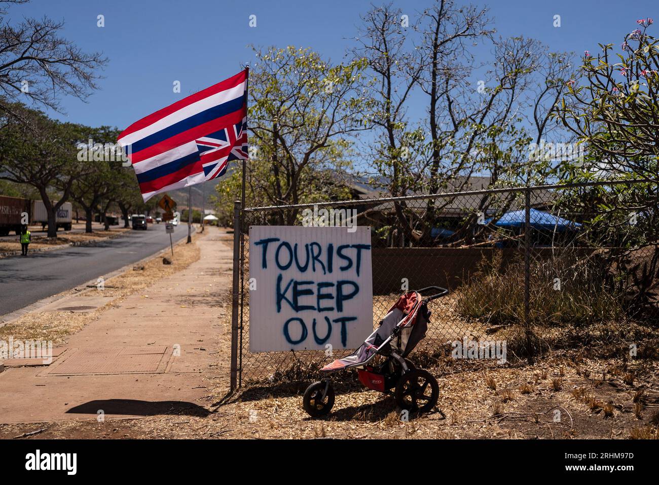A sign that says "Tourist Keep Out" is seen next to a Hawaiian flag