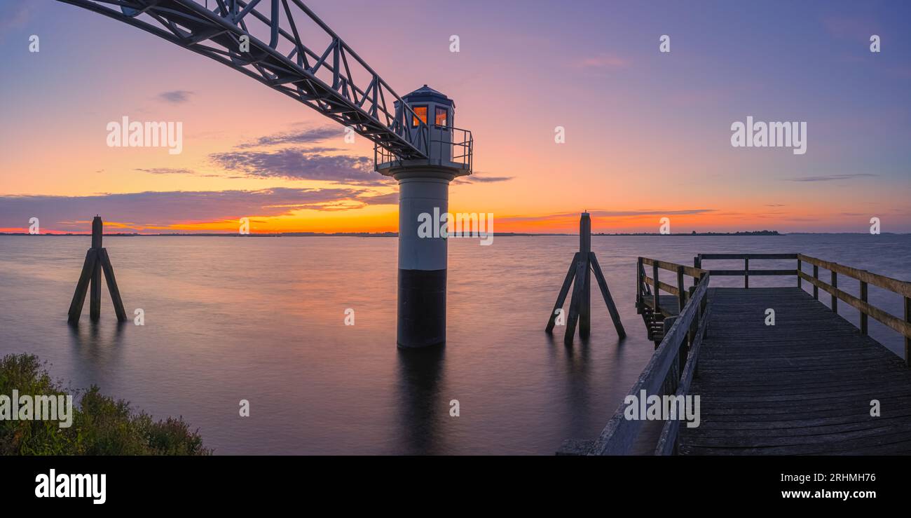 A wide 2:1 panorama photo of a summer sunrise at the lighthouse in Oostmahorn. However, the name lighthouse is not appropriate here, because it is a m Stock Photo