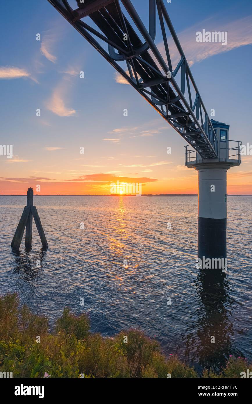 A vertical photo of a summer sunrise at the lighthouse in Oostmahorn. However, the name lighthouse is not appropriate here, because it is a measuring Stock Photo
