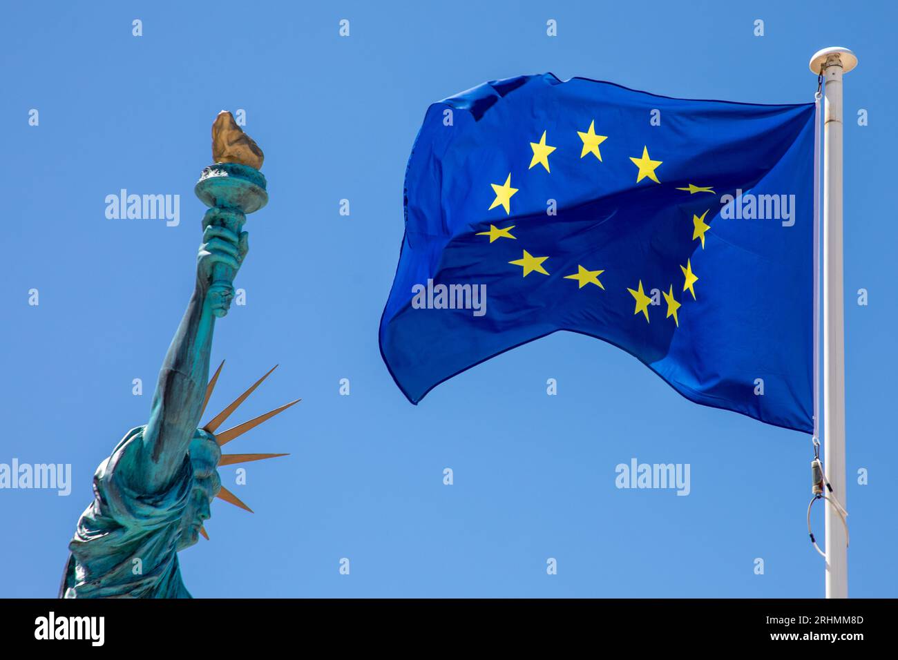 Statue of Liberty with European Union EU Flag yellow stars Waving in mat on blue sky background Stock Photo