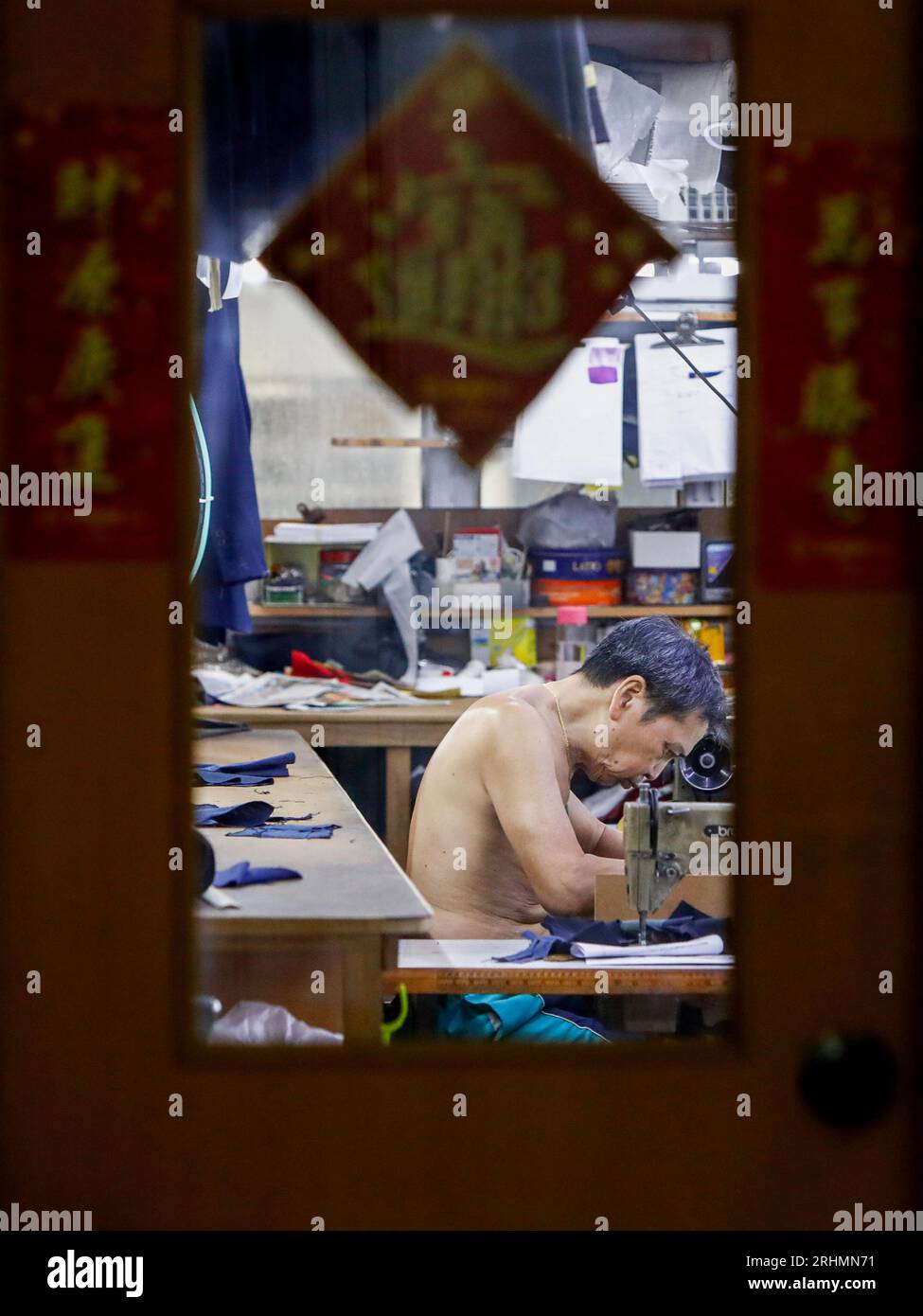 August 18, 2023, Hong Kong, Hong Kong, Hong Kong: A tailor operates a traditional sewing machine inside a mini clothes factory at Mirador Mansion ''“ a historic building comprised of residences, affordable guesthouses and small-scale businesses. Tailor businesses of this kind in Hong Kong are on the edge of extinction as consumption habits have changed over the decades. The building on Nathan Road that features Hong Kong's densely populated population was established in 1959, where manufactures for watches or gloves and tailor shops there flourished during the industrialisation between the 50s Stock Photo
