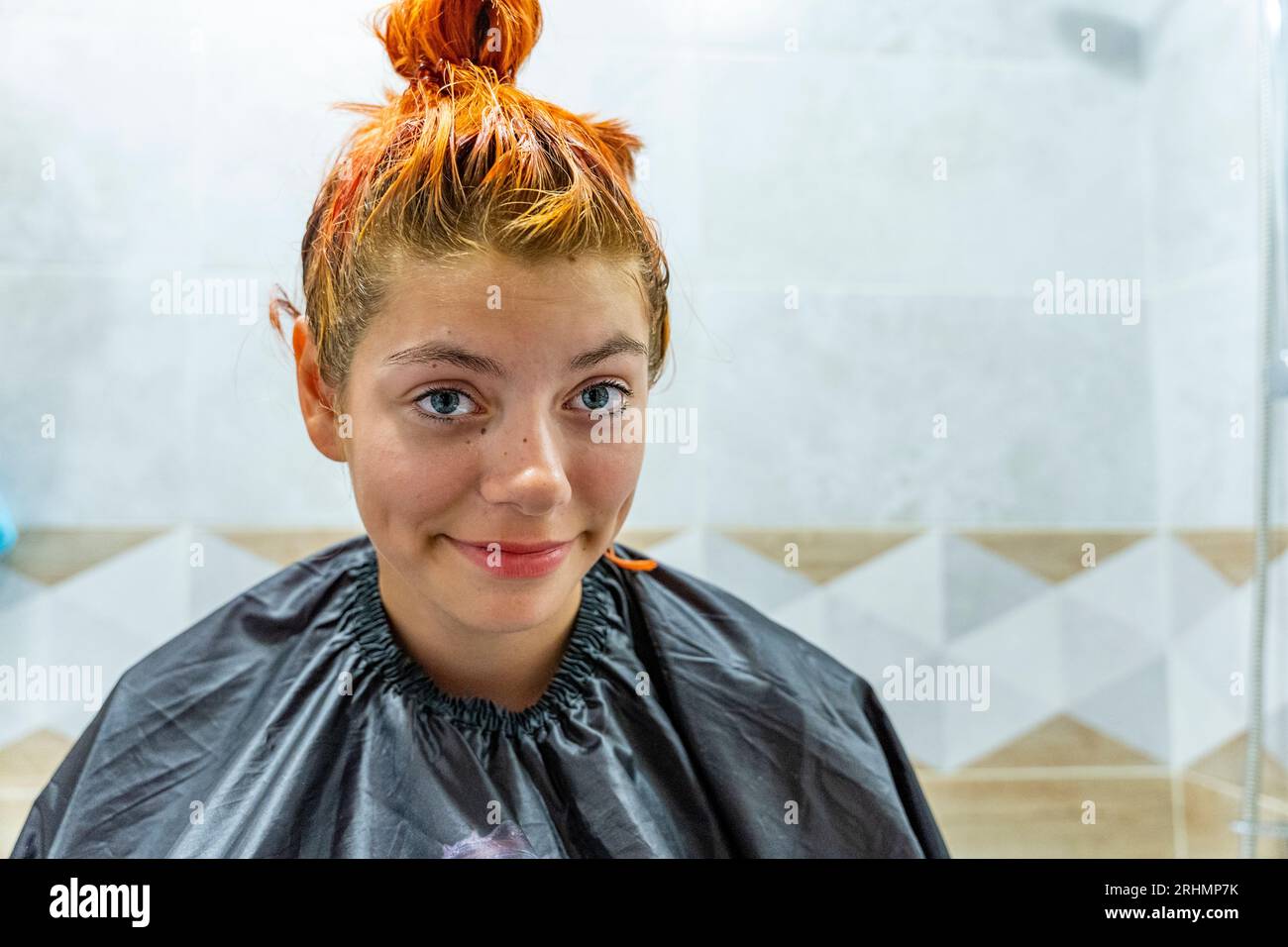 a teenage girl dyes her hair red. The process of dyeing hair red. Self