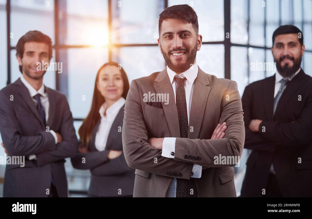 Four business people posing in a modern setting Stock Photo - Alamy
