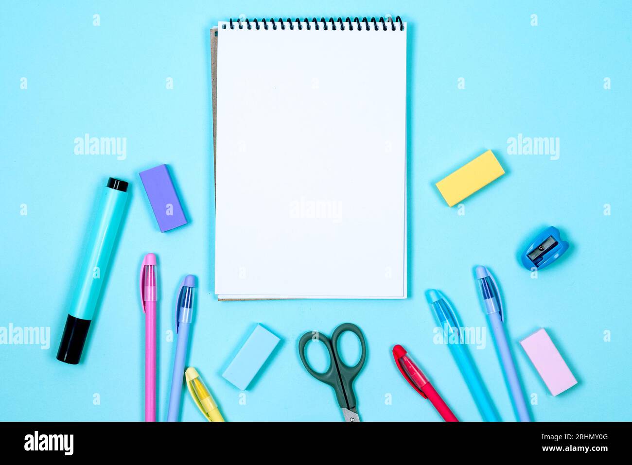 School notebook and various stationery on blue background. Supplies for ...