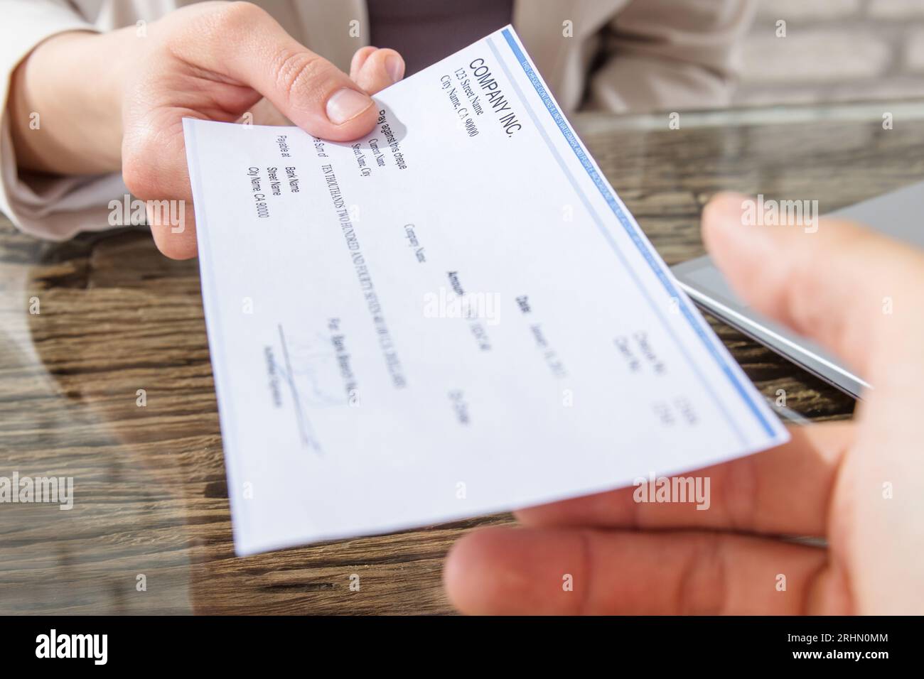 Close-up Of A Business Woman Giving Cheque To Her Colleague At ...
