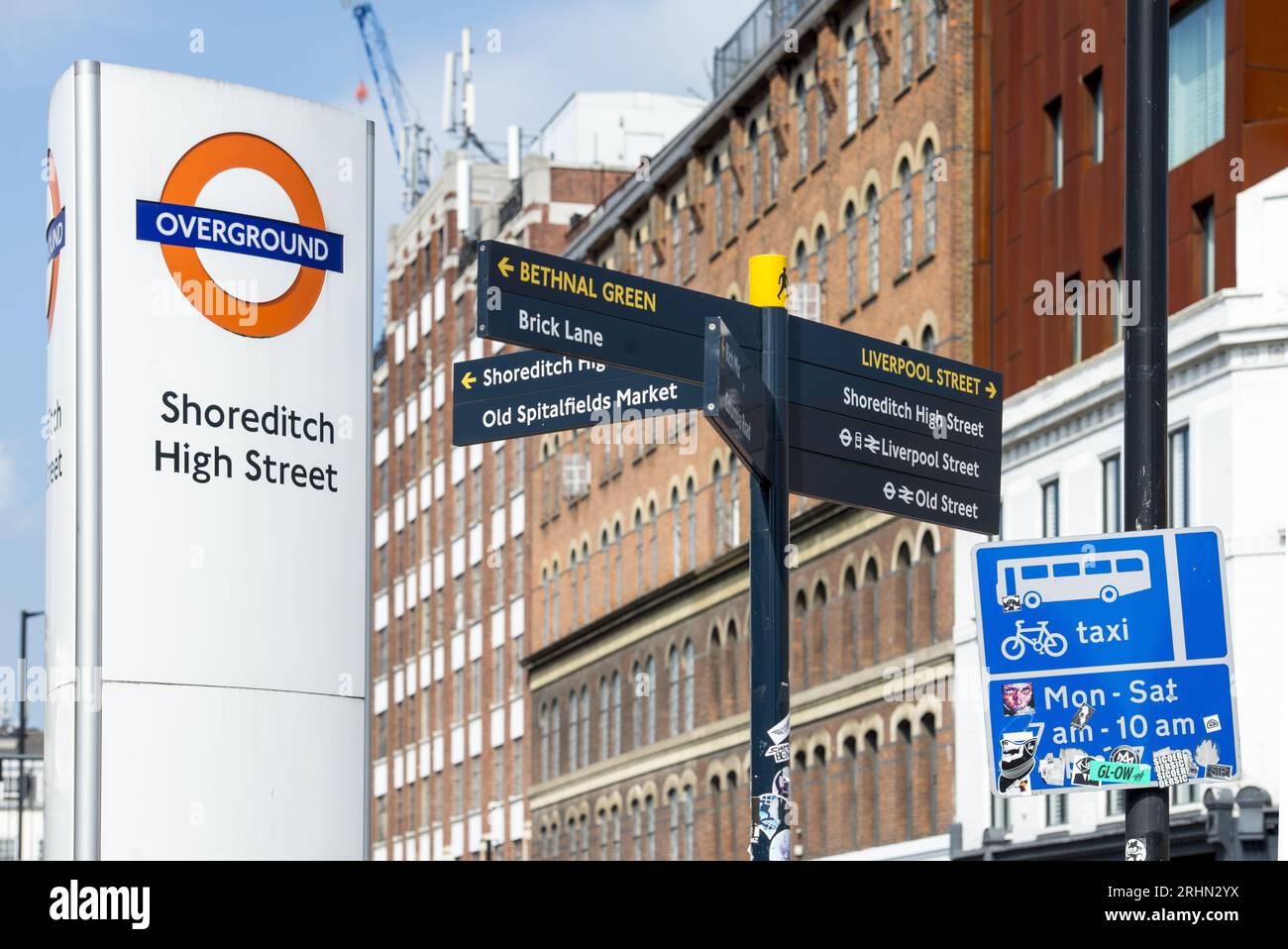 Shoreditch High Street Overground sign and directional street signs in East London, pointing to Brick Lane and Liverpool Street Station. Stock Photo