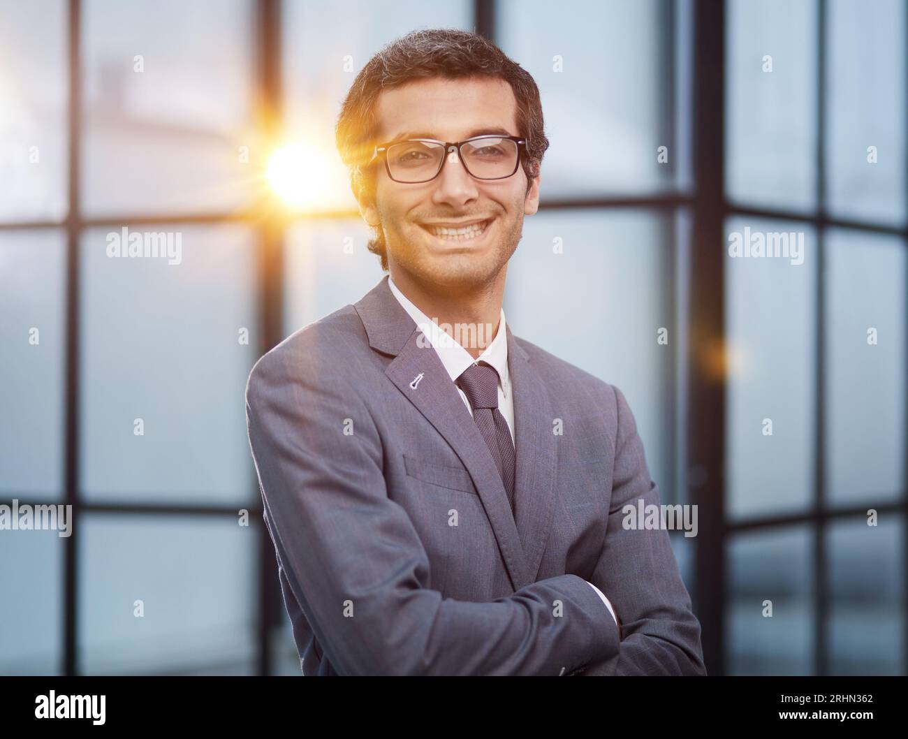 Satisfaction Survey Concept A confident business man with his arms crossed in front of an office building background Stock Photo
