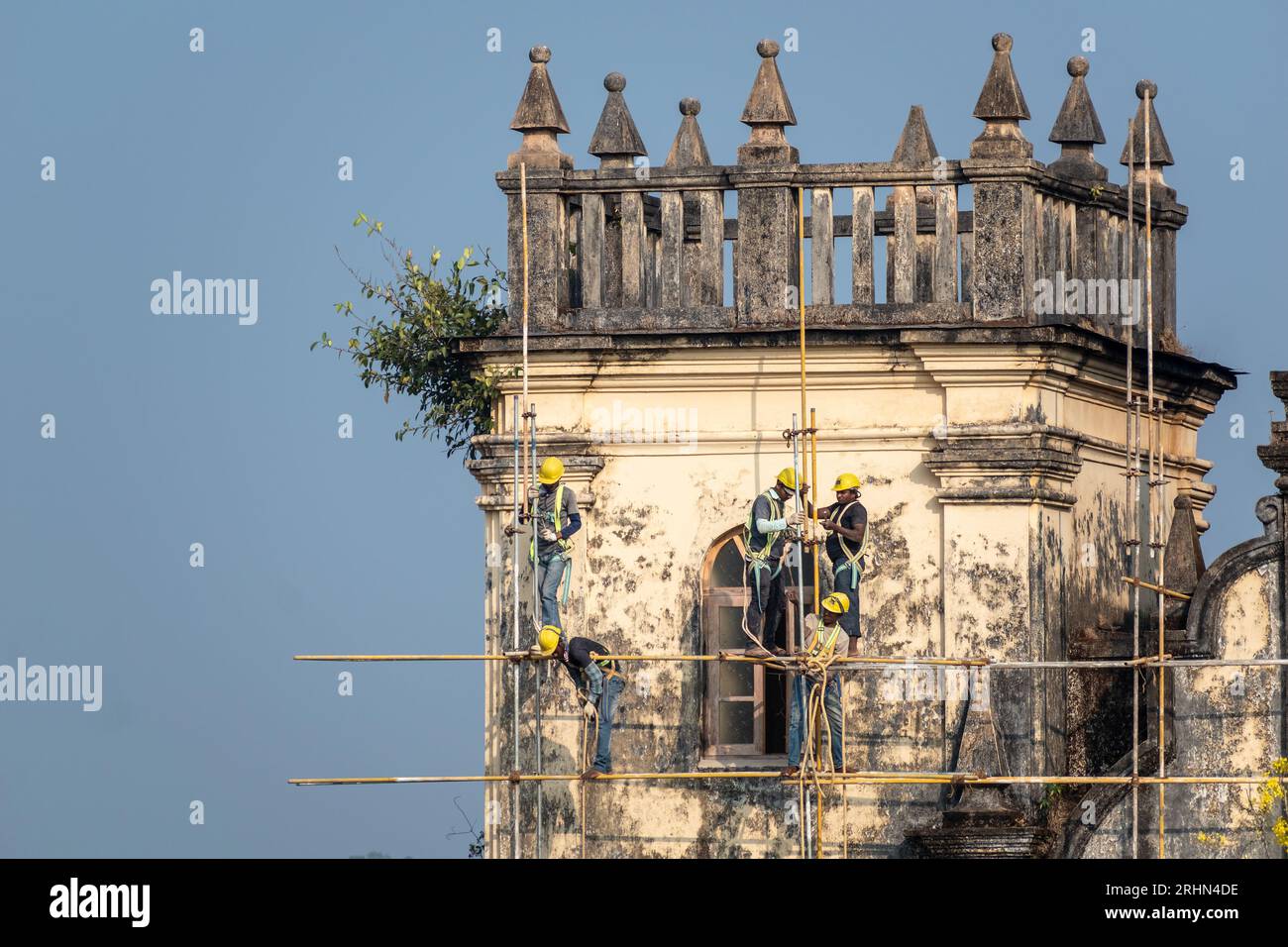 Old Goa, India - January 2023: Indian labourers working on the repair ...