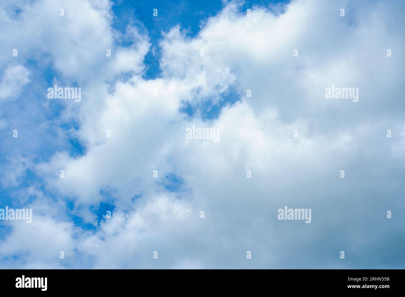 Fluffy white cloud forming condensation on blue sky in sunny day Stock Photo