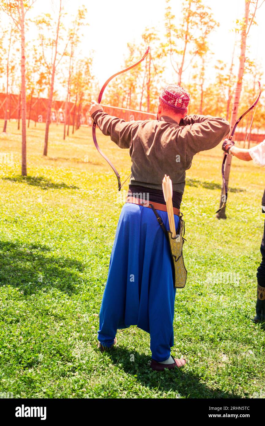Archer in traditional clothes shooting an arrow Stock Photo Alamy