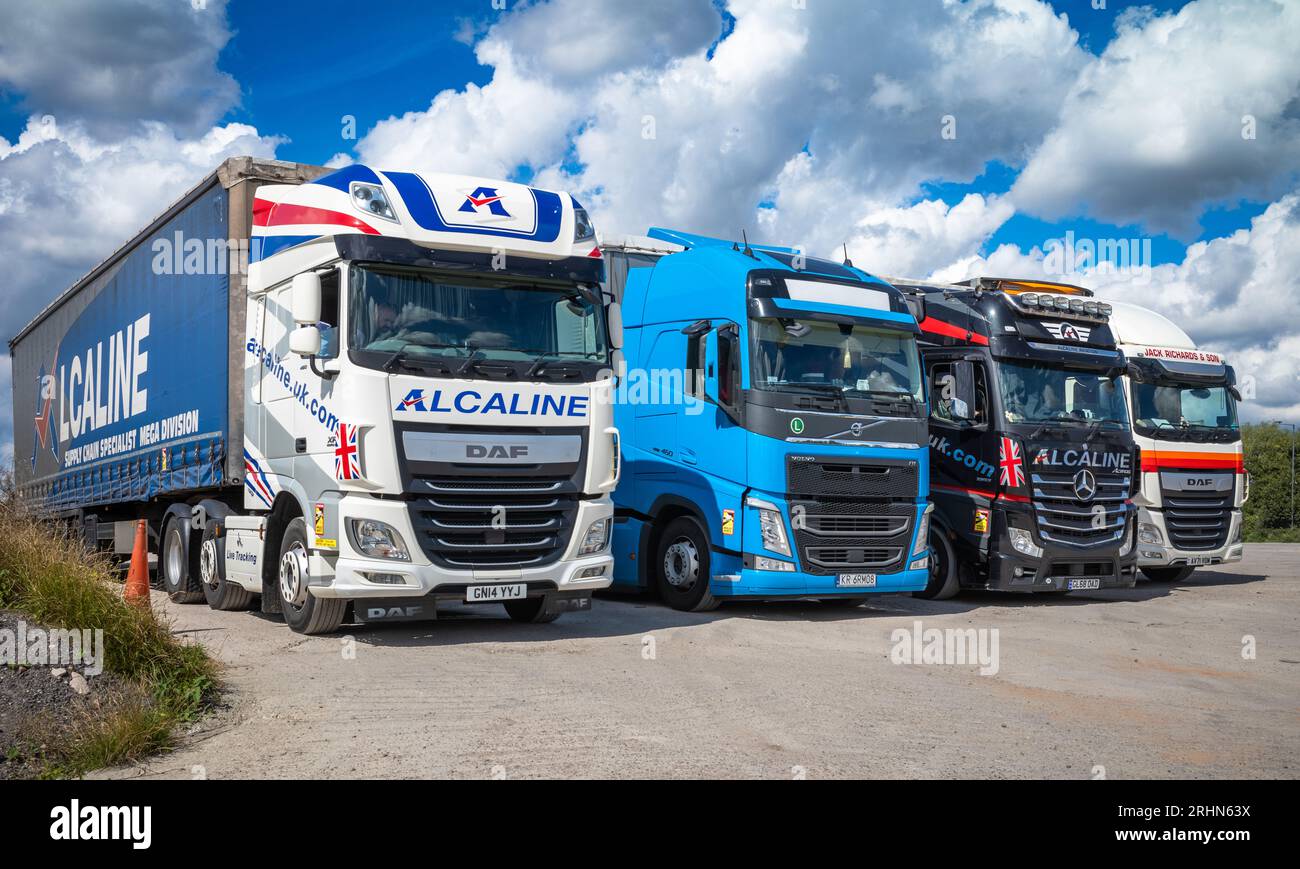 Four commercial articulated lorries or trucks each with a load capacity of up to 44 tonnes parked in a line at the Lincoln Farm Truck Stop in Balsall Stock Photo