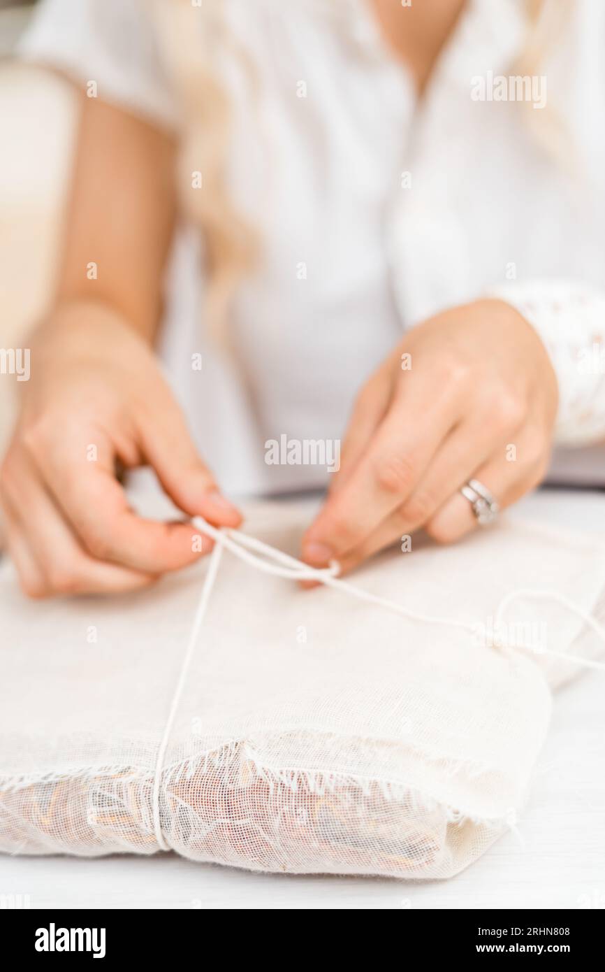 A woman tying a package with linen cloth and string Stock Photo Alamy