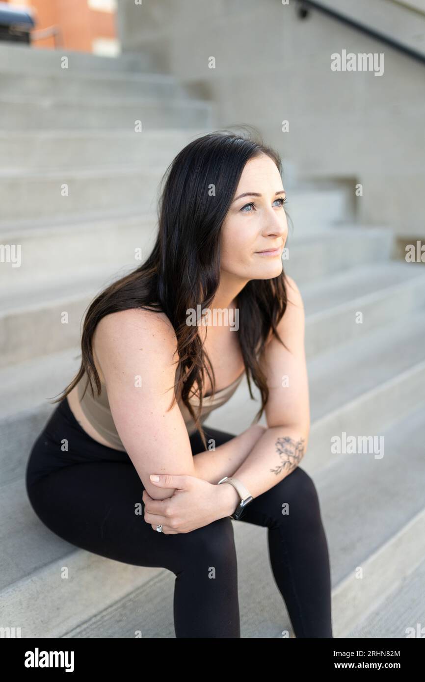 A woman sitting on cement stairs Stock Photo