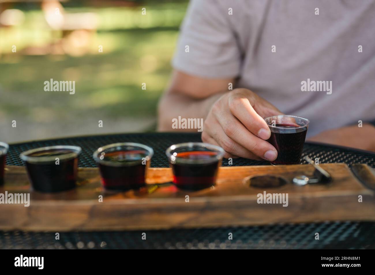 Young person enjoying red wine at wine tasting event at a vineyard Stock Photo