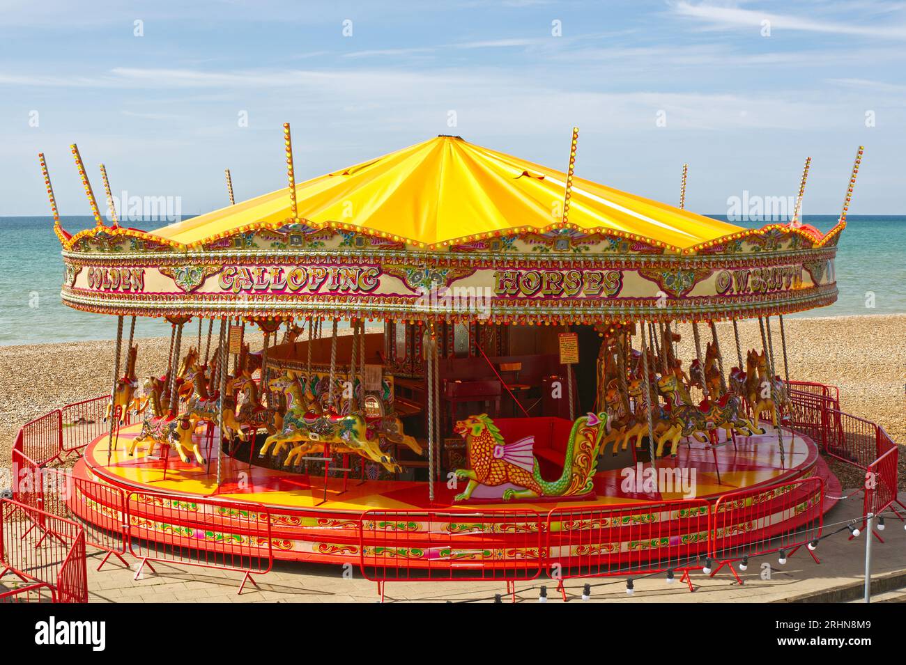 Traditional fairground roundabout on the beach at Brighton in East Sussex, England. No people. Stock Photo