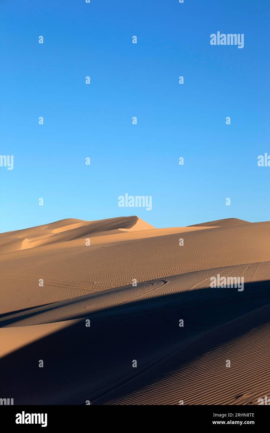 Sand dunes with wheel ruts and patterns in sand vertical Stock Photo