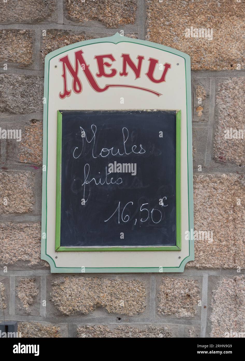 menu outdoors on a wall from a restaurant written 'moules frites' on it (means: shells fries) Stock Photo
