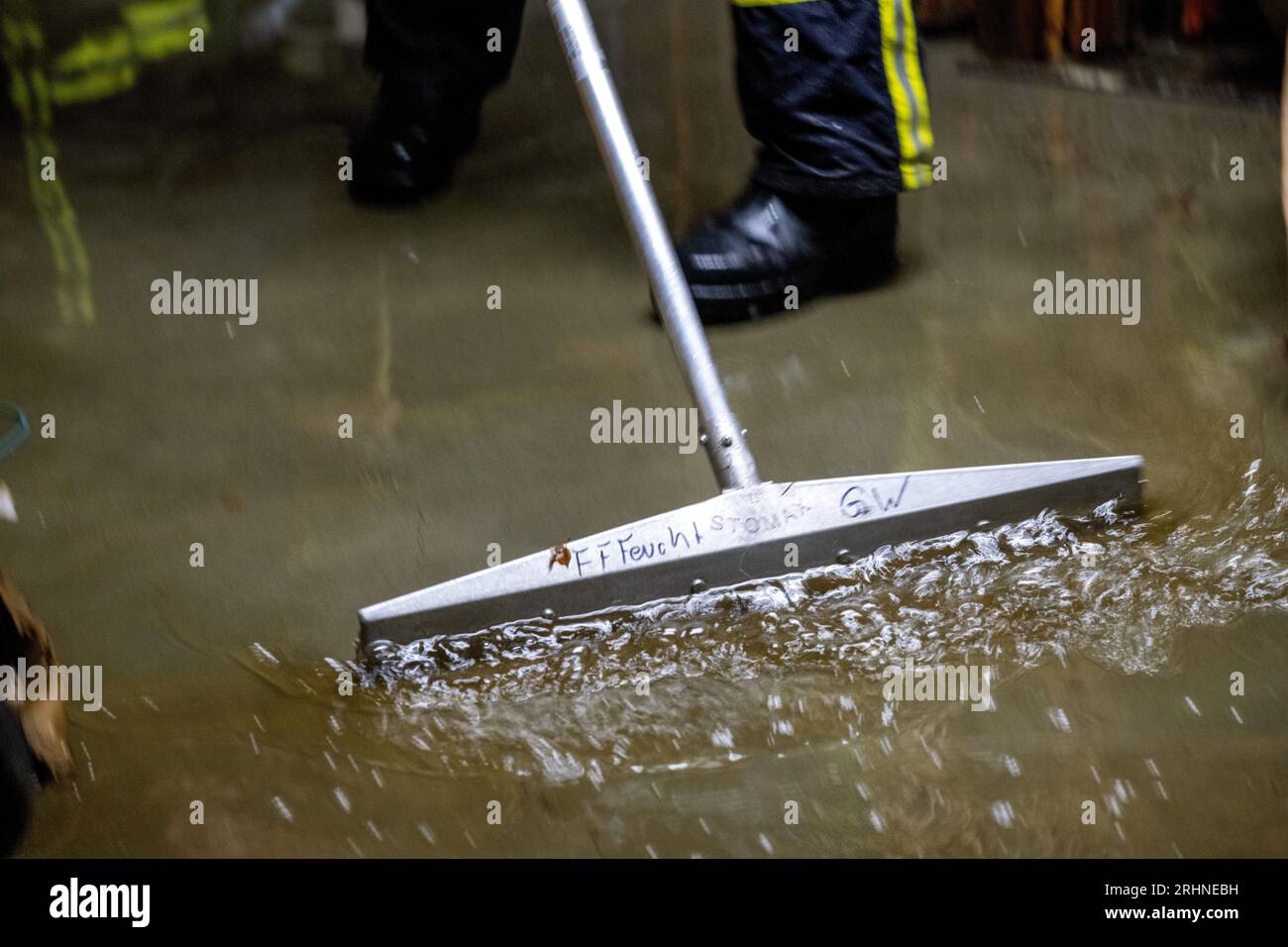 Nuremberg, Deutschland. 18th Aug, 2023. Firefighters sweep up the water in a cellar and suck it out. After the severe storms, the fire departments in Nuremberg are still in continuous operation and pumping out numerous cellars. Credit: Pia Bayer/dpa/Alamy Live News Stock Photo