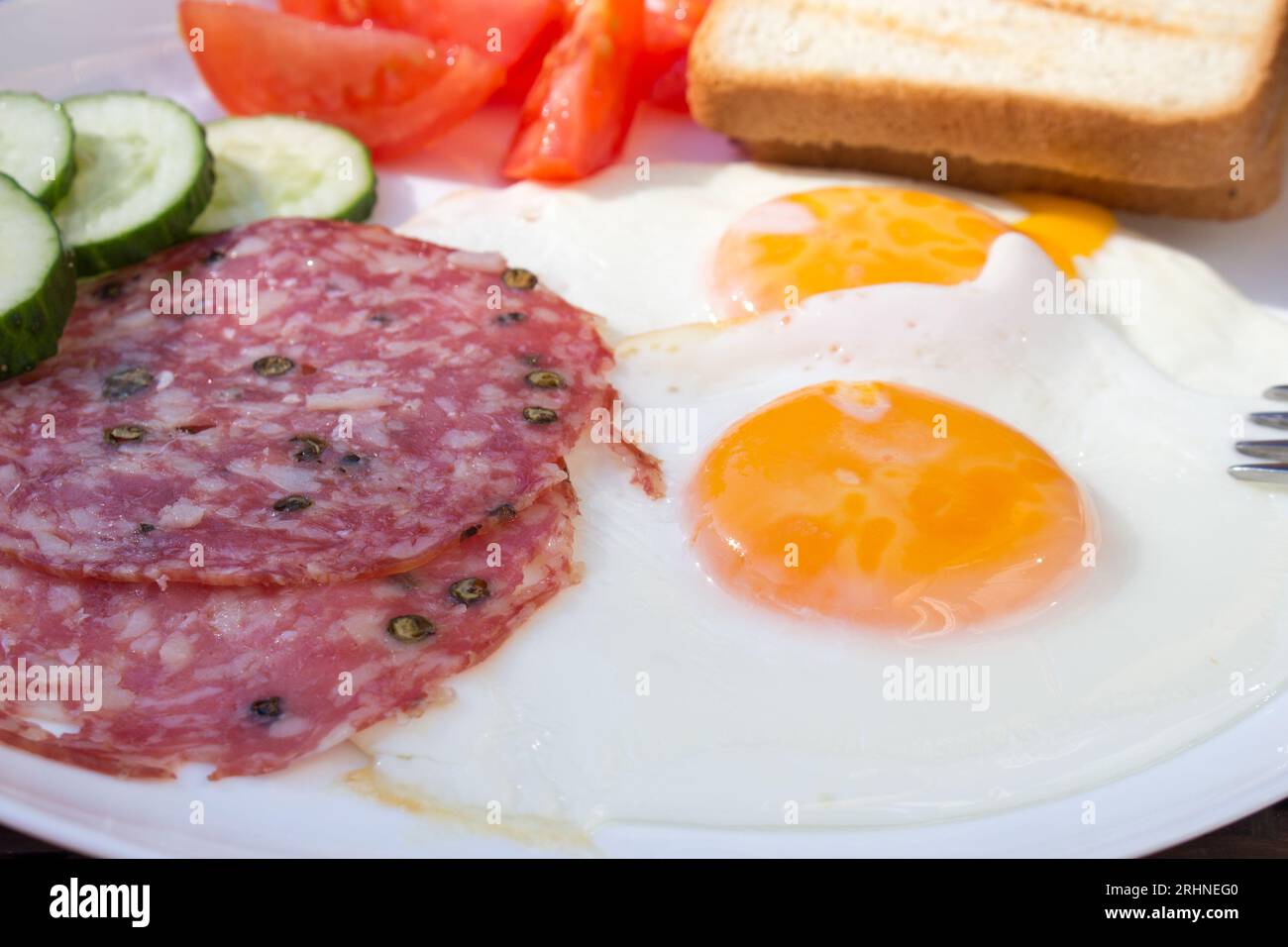 A closeup photograph of a traditional breakfast, featuring fried eggs