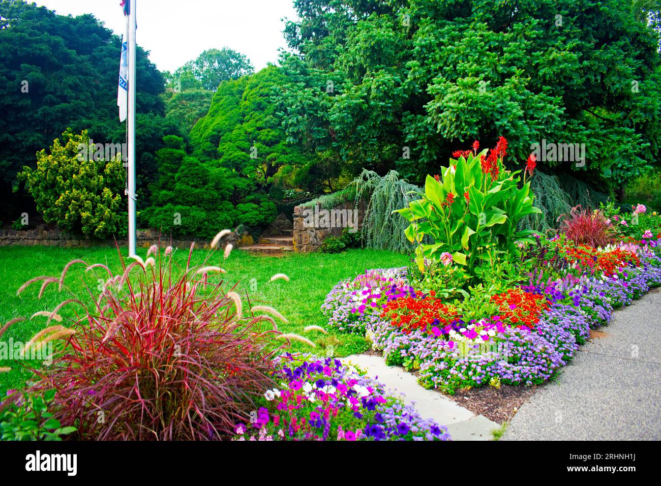 A variety of colorful flowers in a bed in front of a stone stairway in a local garden park -02 Stock Photo