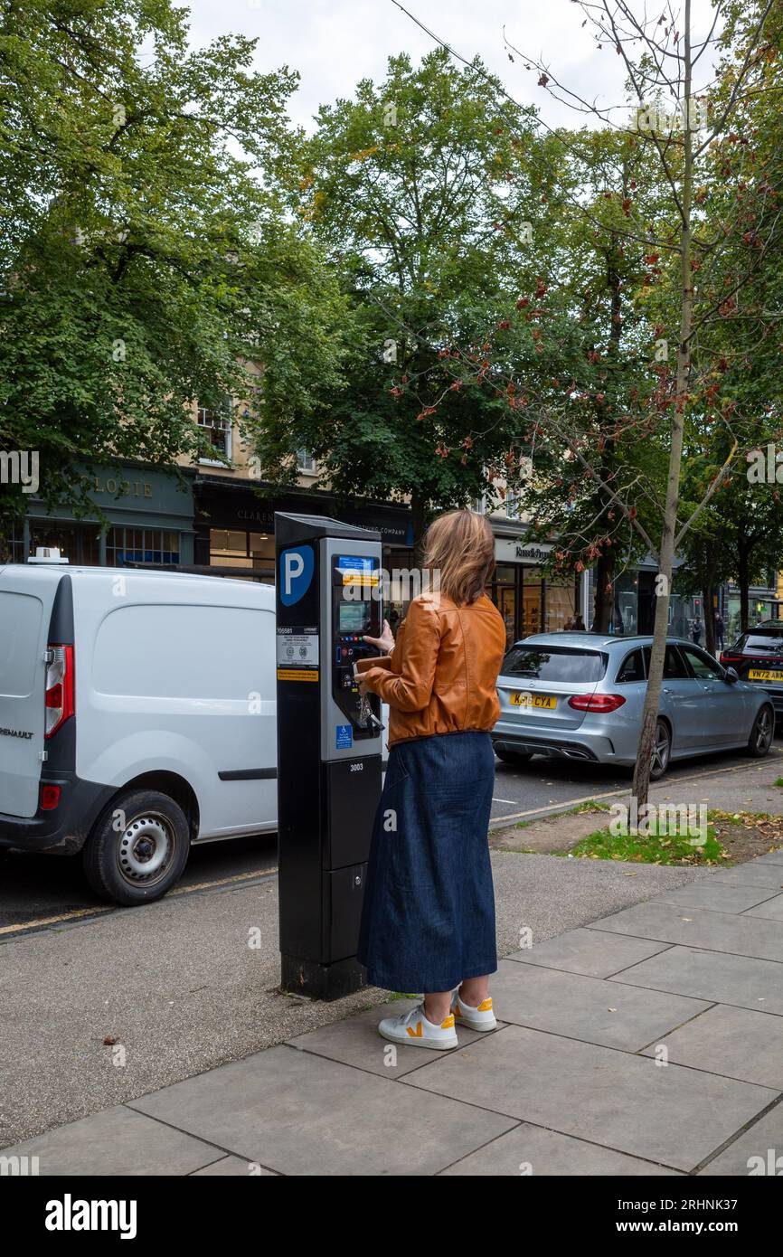 Woman purchasing a packing ticket, Cheltenham, UK Stock Photo