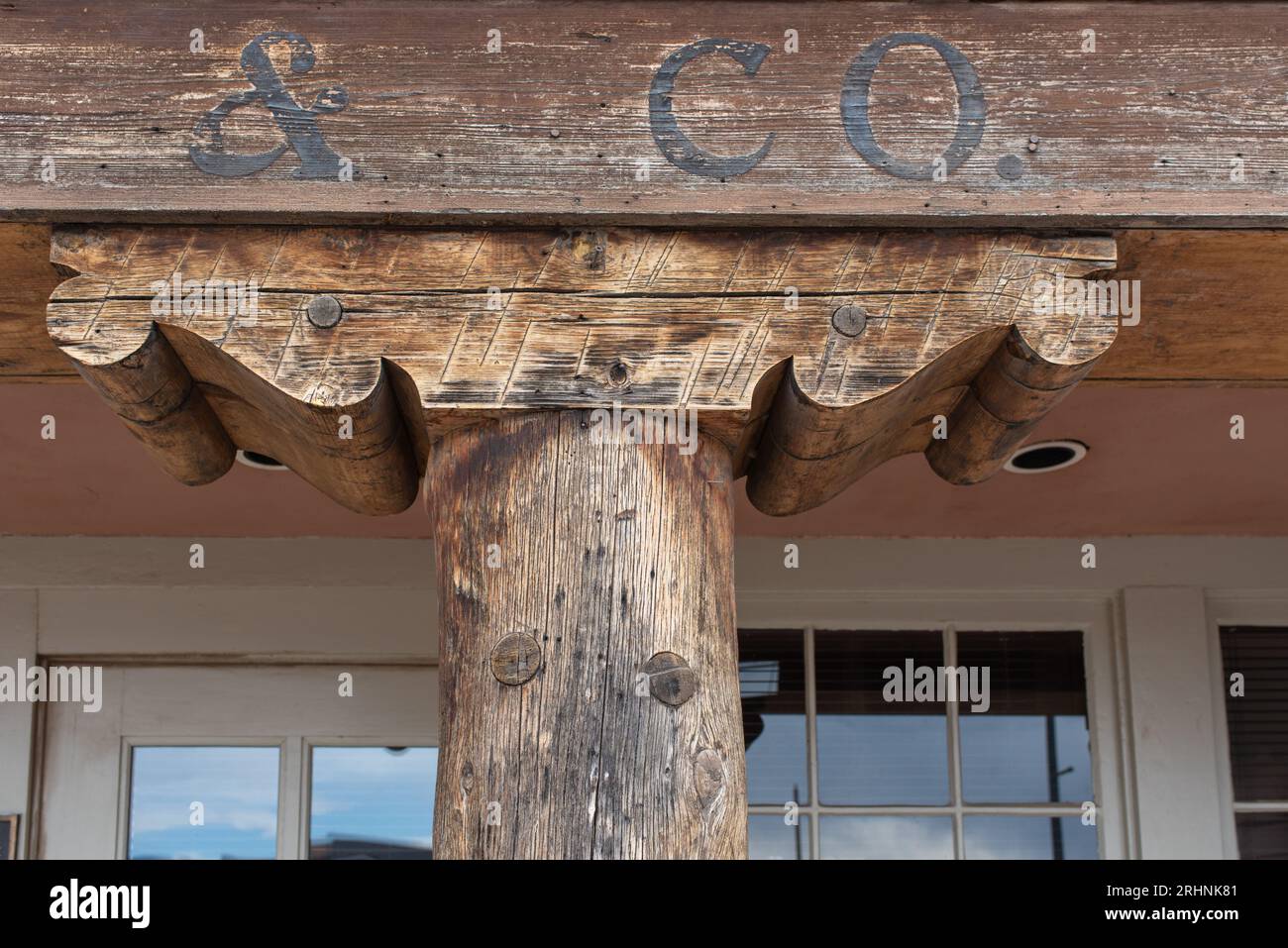 An old corbel, probably hand cut, helps distribute the weight of a heavy beam, traditional architecture in Santa Fe, New Mexico, USA. Stock Photo
