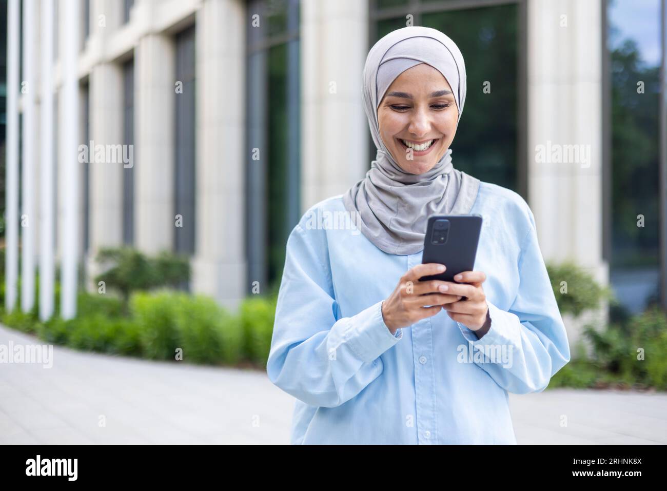 A young beautiful business woman in a hijab walks through the city, a ...
