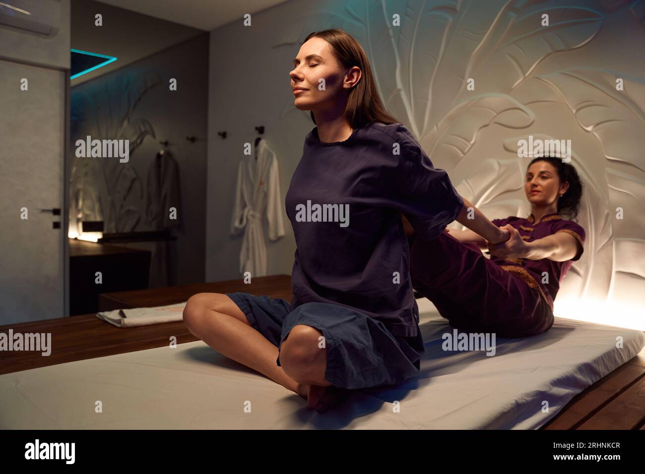 experienced-masseuse-is-stretching-female-client-thoracic-spine-stock