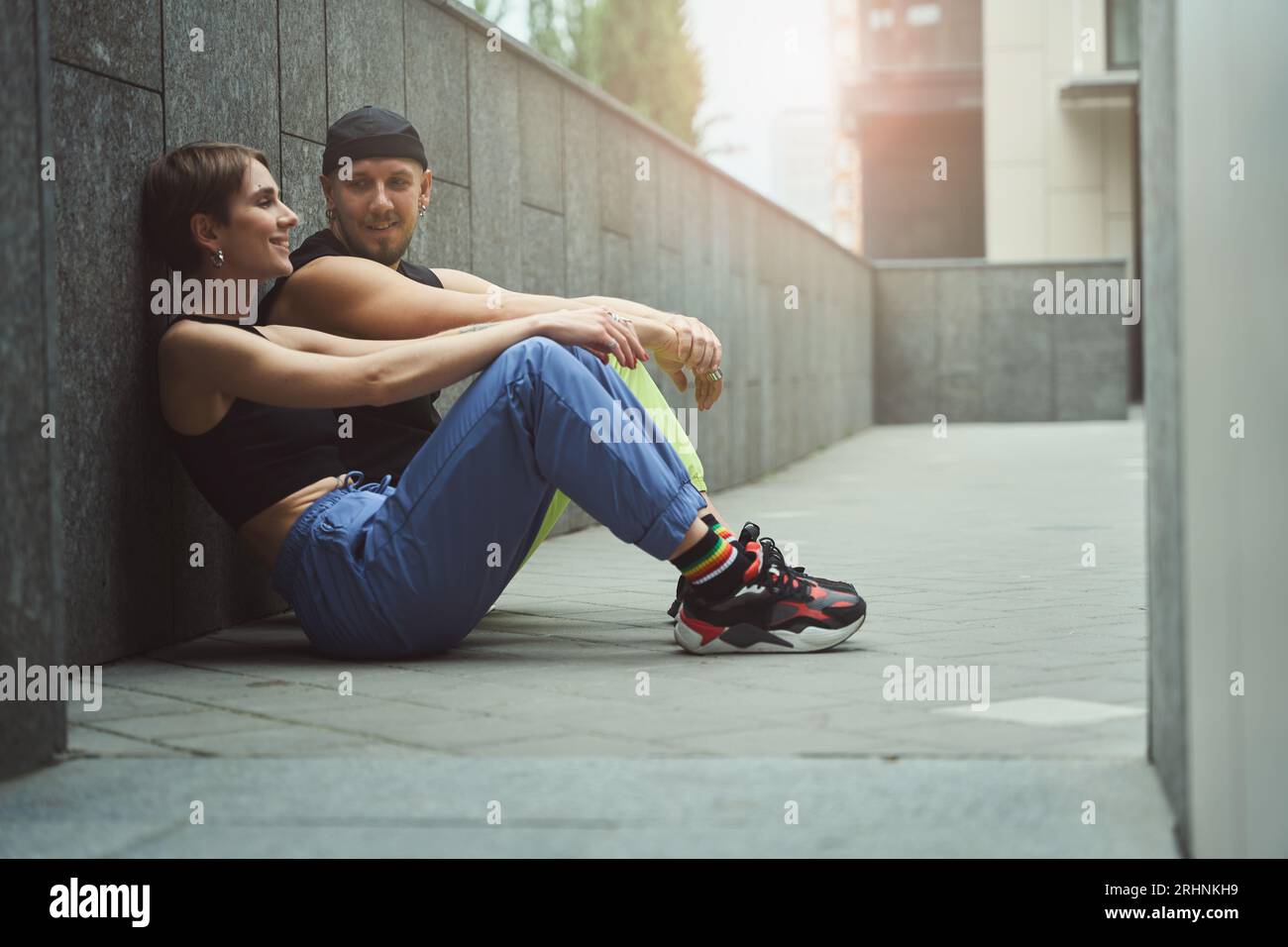 Pretty young female and her informal friend chat in small courtyard Stock Photo