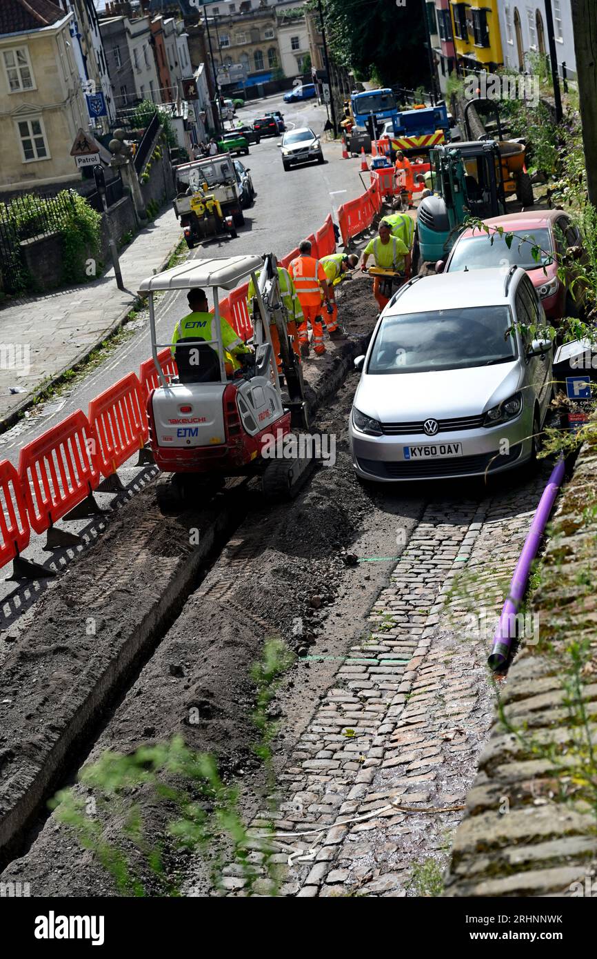 Roadworks, trenching for fibre optic cable, made slightly awkward with cars parked in work area, St Michael's Hill, Bristol Stock Photo
