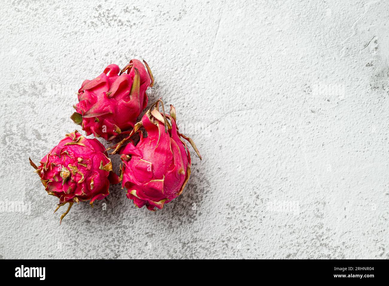 Ripe red dragon fruit on stone table Stock Photo