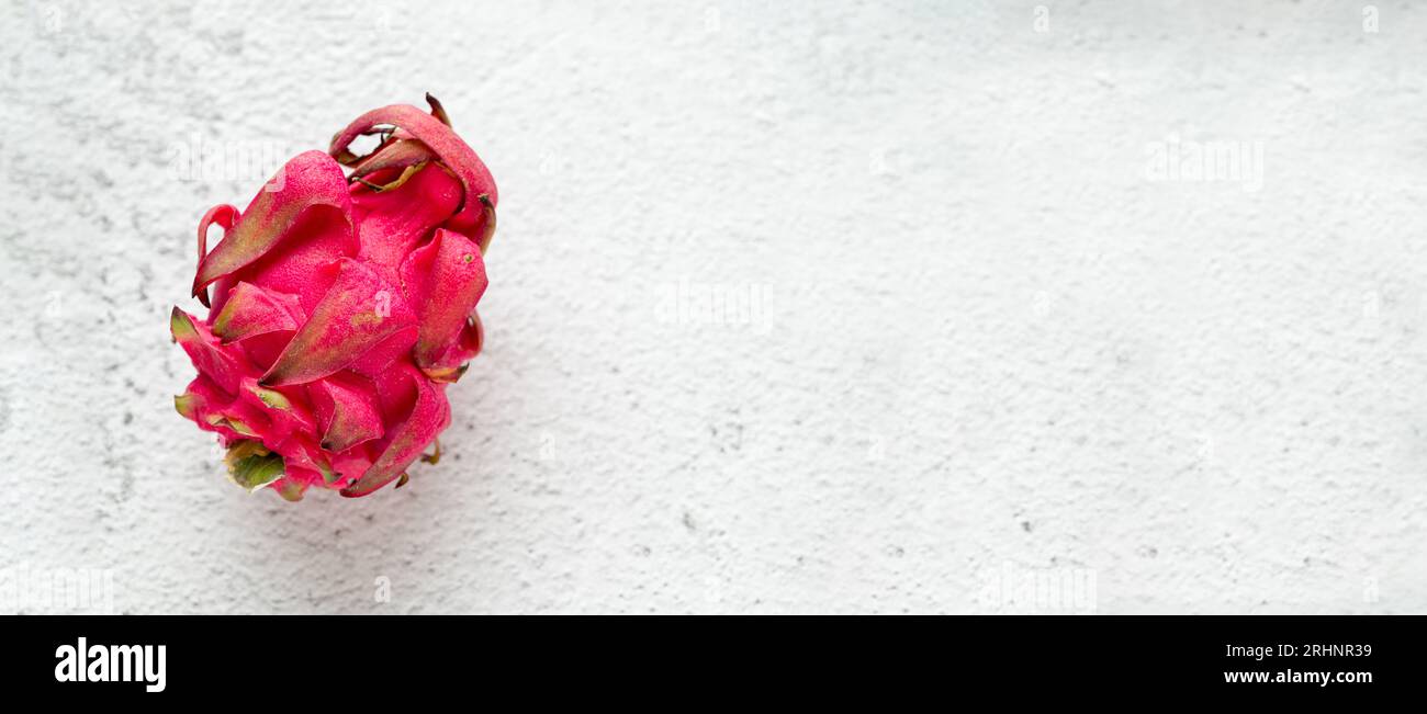 Ripe red dragon fruit on stone table Stock Photo