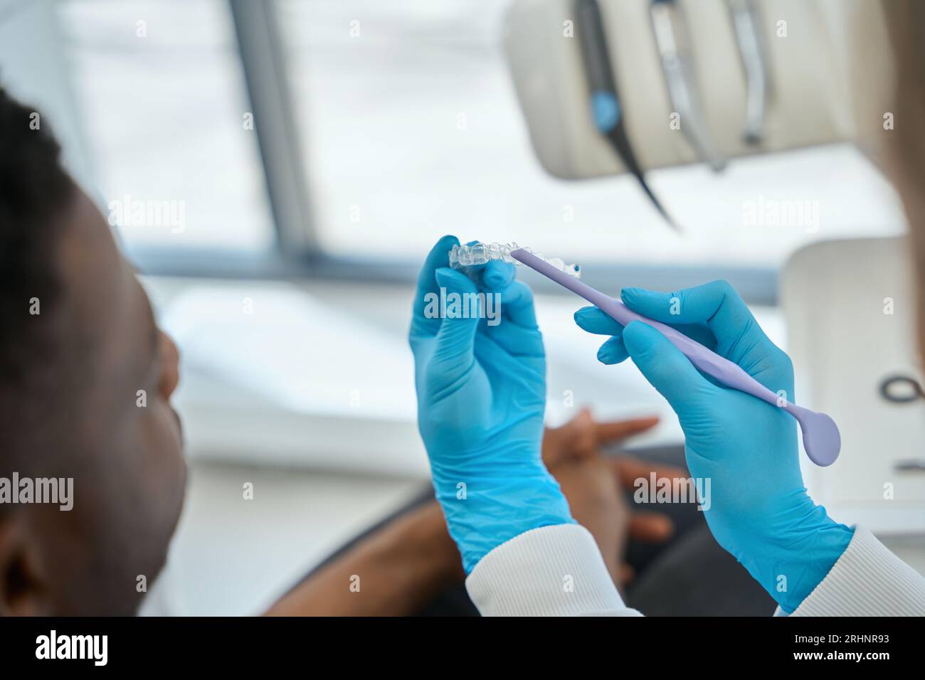 Dentist showing to male client invisible aligners Stock Photo - Alamy