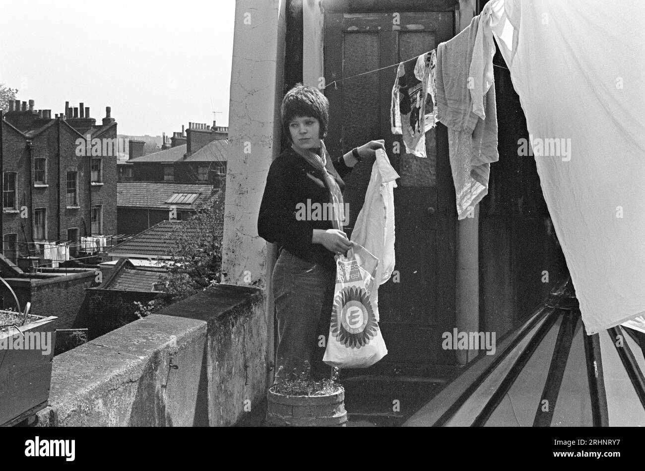 Clothesline, young woman 1960s, student living in a squat, hanging out washing on balcony of a bed sitter flat. St Johns Wood, London, England 1969  UK HOMER SYKES Stock Photo