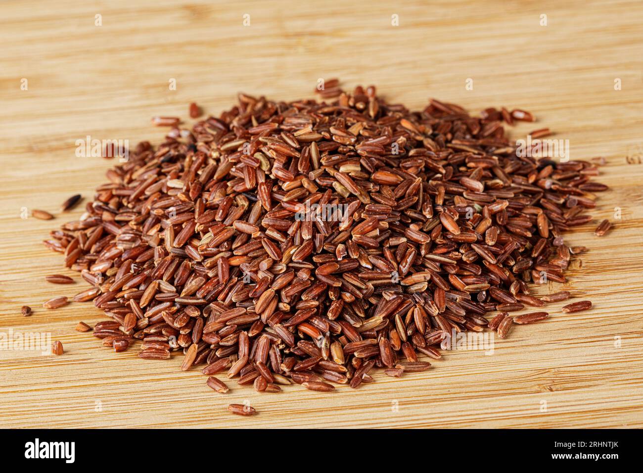 Close up of delicious and healthy Red Rice isolated on a wooden cutting board with copy space Stock Photo
