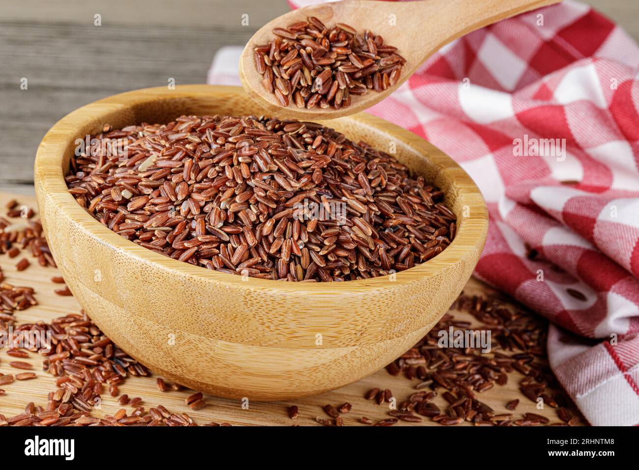 A Wooden Bowl of delicious and healthy Red Rice isolated on a wooden background with copy space Stock Photo