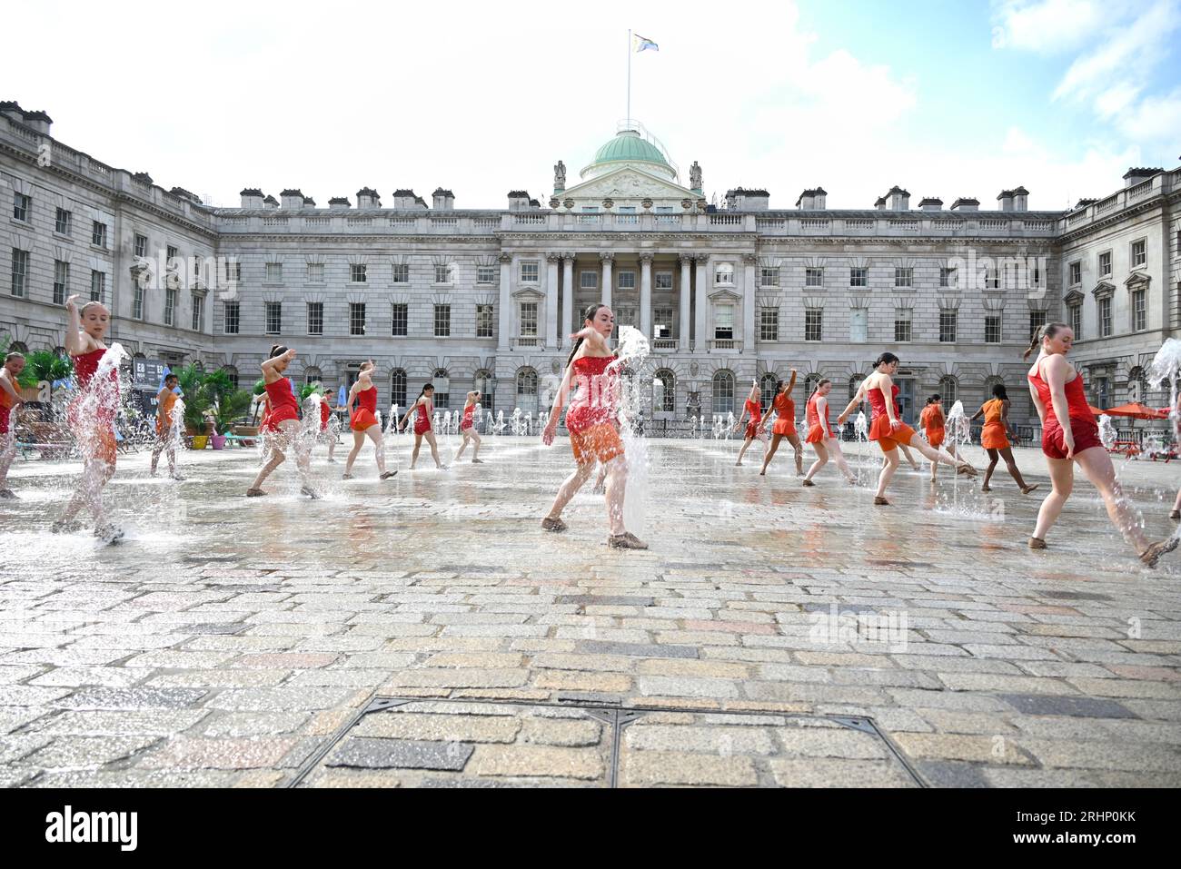 22 all-female dancers in vivid orange costumes designed by Ursula ...