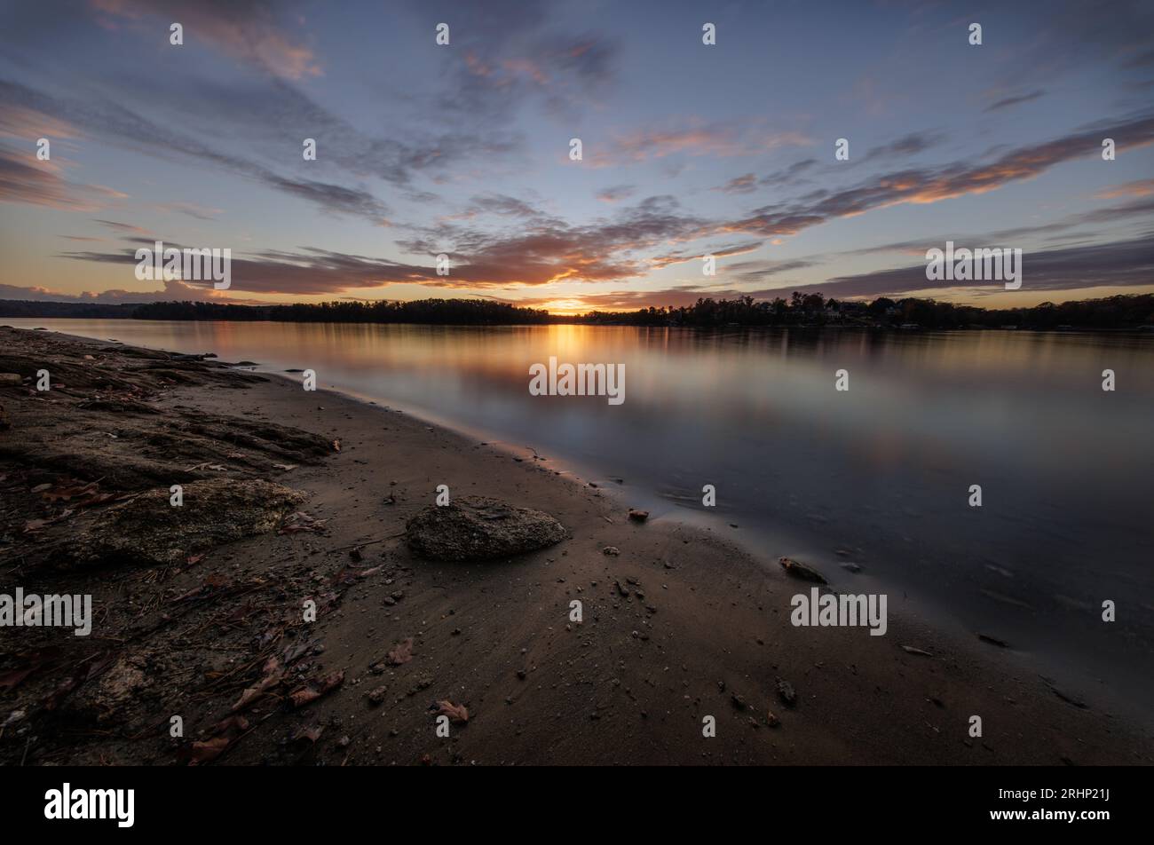 The sun sets over the calm surface of Lake Lanier at Holly Park. Stock Photo