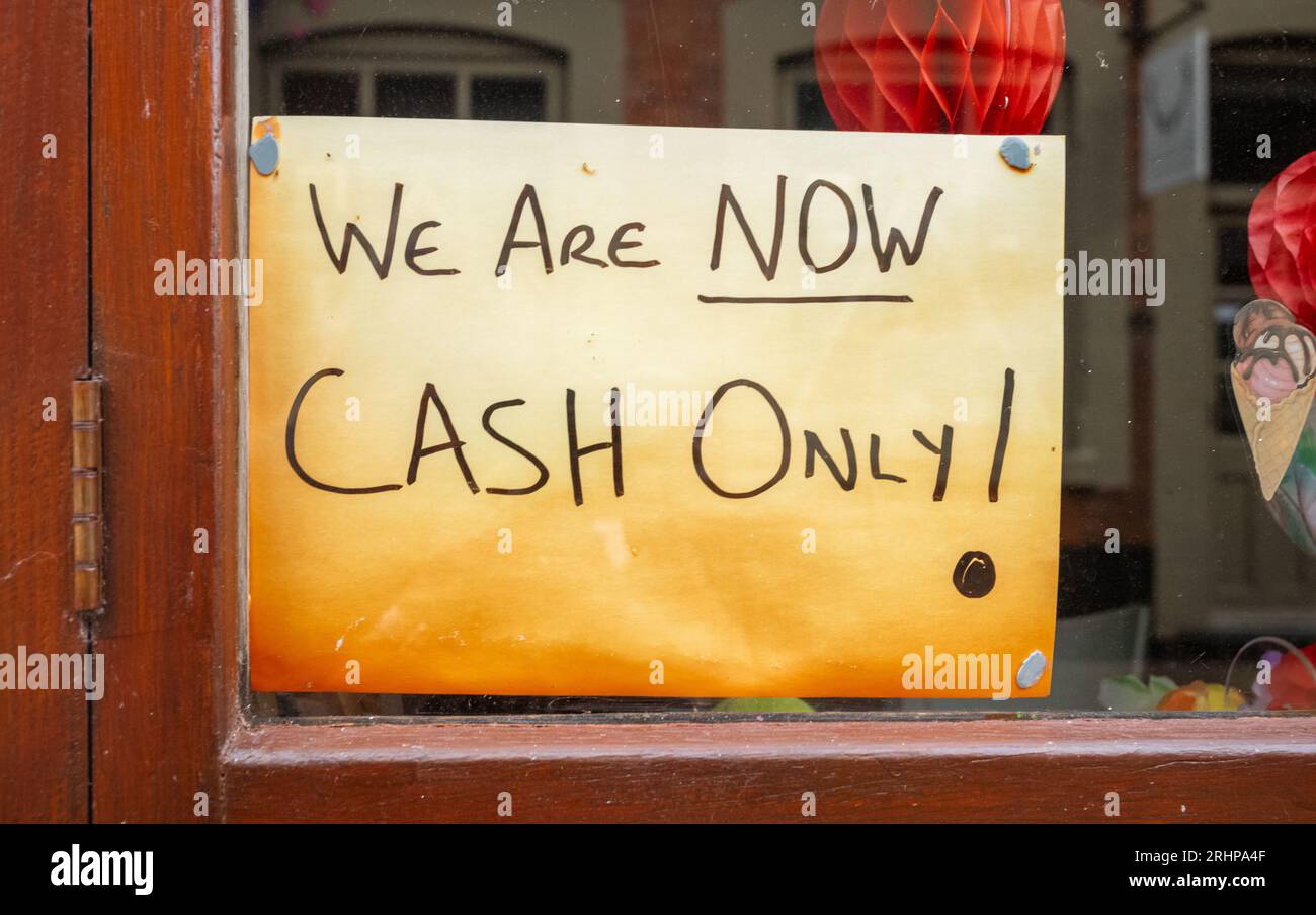 A handwritten sign stuck to a shop window stating they now only accept cash and no card payments in Lichfirld, Staffordshire, UK. It is increasingly r Stock Photo