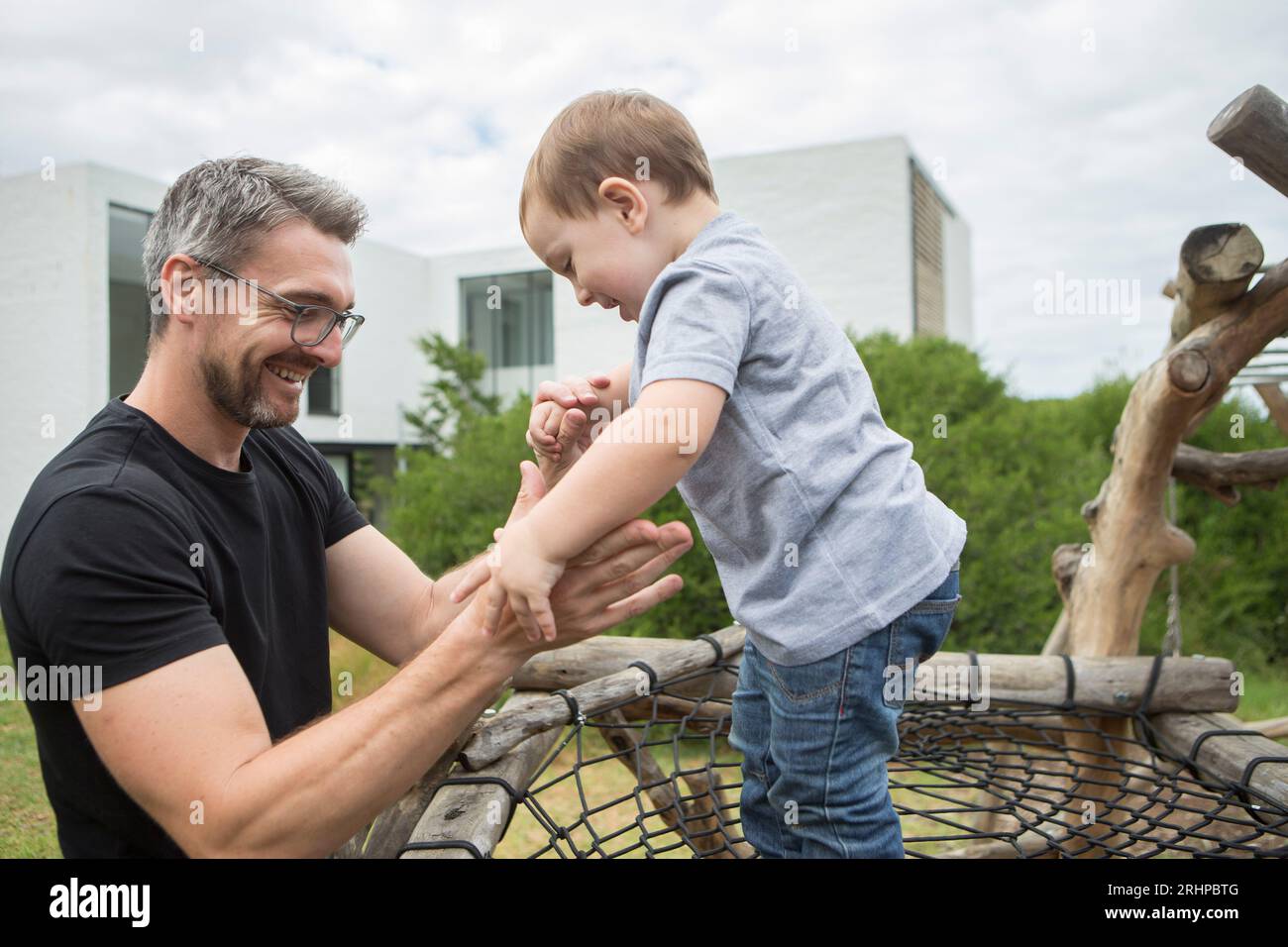 Father with his child on a climbing frame Stock Photo