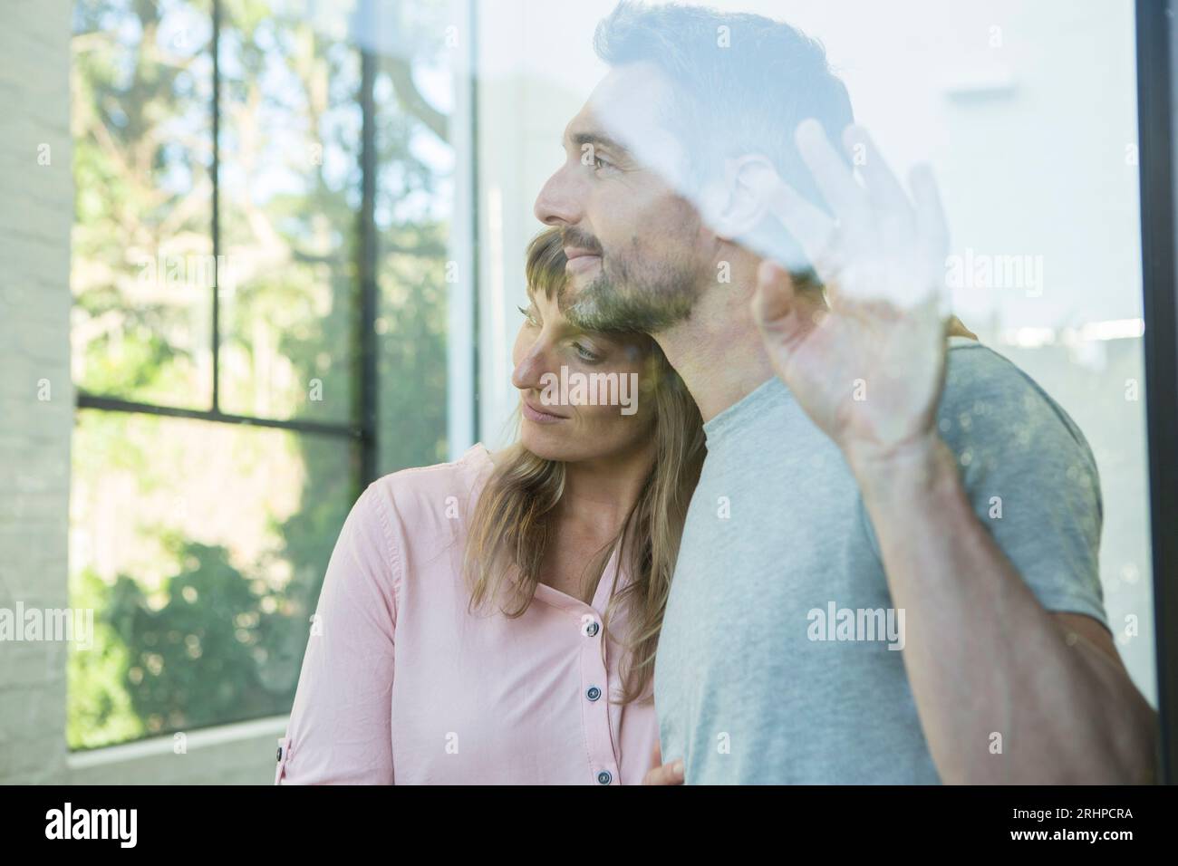 Couple looks pensively out of window Stock Photo
